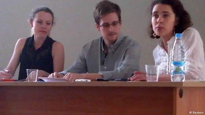 Former intelligence agency contractor Edward Snowden (C) and Sarah Harrison (L) of WikiLeaks speak to human rights representatives in Moscow's Sheremetyevo airport July 12, 2013. Snowden is seeking temporary asylum in Russia and plans to go to Latin America eventually, an organisation endorsed by anti-secrecy group Wikileaks said on Twitter on Friday. The person at right is unidentified. REUTERS/Human Rights Watch/Handout (RUSSIA - Tags: POLITICS SOCIETY TPX IMAGES OF THE DAY) NO COMMERCIAL OR BOOK SALES. NO SALES. NO ARCHIVES. FOR EDITORIAL USE ONLY. NOT FOR SALE FOR MARKETING OR ADVERTISING CAMPAIGNS. THIS IMAGE HAS BEEN SUPPLIED BY A THIRD PARTY. IT IS DISTRIBUTED, EXACTLY AS RECEIVED BY REUTERS, AS A SERVICE TO CLIENTS