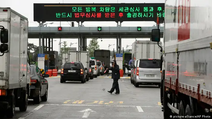 A security officer directs South Korean vehicles as they leave for South and North Korea's joint Kaesong Industrial Complex to bring back their finished goods and materials at the customs, immigration and quarantine office of the Inter-Korean Transit Office near the border village of Panmunjom, which has separated the two Koreas since the Korean War, in Paju, north of Seoul, South Korea, Monday, July 15, 2013. Talks aimed at restarting the factory park ended Wednesday with no breakthrough, but both sides agreed to meet again Monday to discuss restoring what was once a symbol of cooperation between the rivals. (AP Photo/Lee Jin-man)
