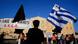 A woman holds a Greek and a black flag as she stands in front of the parliament during an anti-austerity protest in Athens July 17, 2013. Prime Minister Antonis Samaras announced Greece's first major tax cut since its crisis began nearly four years ago, highlighting a hard-won concession just hours before lawmakers vote on a bill to eliminate thousands of public sector jobs. REUTERS/Yannis Behrakis (GREECE - Tags: POLITICS BUSINESS CIVIL UNREST EMPLOYMENT) A woman holds a Greek and a black flag as she stands in front of the parliament during an anti-austerity protest in Athens July 17, 2013. Prime Minister Antonis Samaras announced Greece's first major tax cut since its crisis began nearly four years ago, highlighting a hard-won concession just hours before lawmakers vote on a bill to eliminate thousands of public sector jobs. REUTERS/Yannis Behrakis (GREECE - Tags: POLITICS BUSINESS CIVIL UNREST EMPLOYMENT)