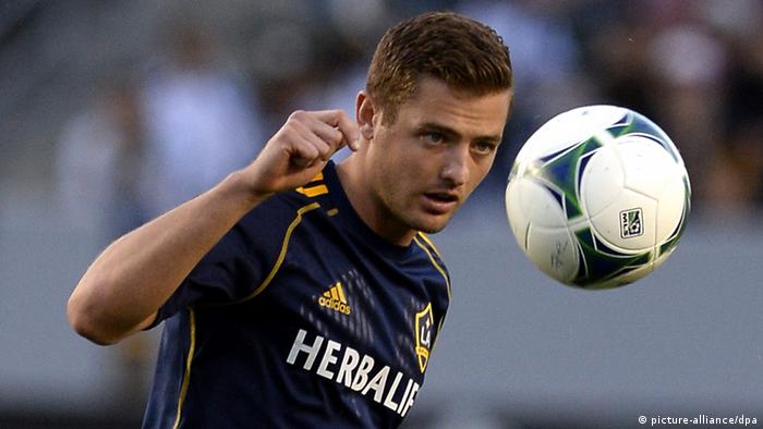American soccer player Robbie Rogers heads a soccer ball during a game.