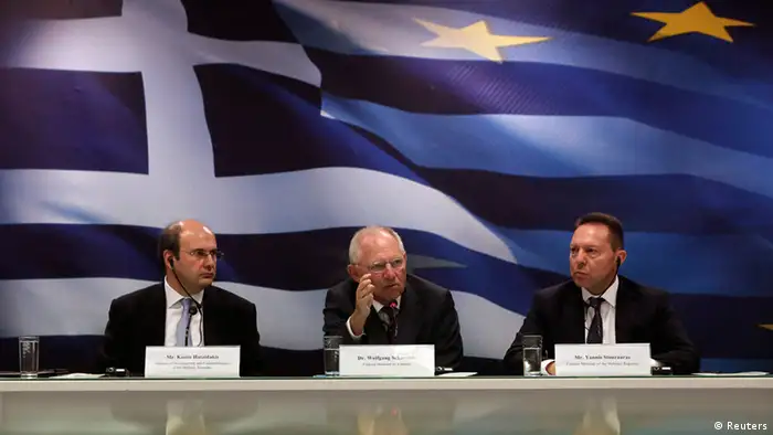 German Finance Minister Wolfgang Schaeuble (C) gestures while flanked by his Greek counterpart Yannis Stournaras (R) and Greece's Minister for Development & Competitiveness Kostis Hatzidakis during a news conference at Greece's Ministry of Finance in Athens July 18, 2013. Schaeuble is willing to discuss further help for Greece if it reforms successfully but it still needs support at the end of a current international bailout programme, he said during the trip to Athens on Thursday. REUTERS/John Kolesidis (GREECE - Tags: POLITICS BUSINESS)