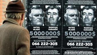 Ein Mann steht vor Fandungsplakate von Radovan Karadzic und Ratko Mladic (Photo: EPA/FEHIM DEMIR +++(c) dpa - Bildfunk+++)