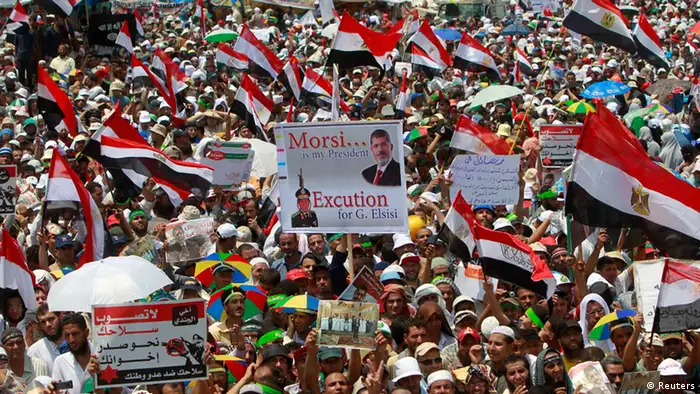 Supporters of deposed Egyptian President Mohamed Mursi hold up signs and flags during a protest at the Rabaa Adawiya square where they are camping at in Cairo July 19, 2013.Thousands of supporters of Mursi rallied in Cairo on Friday to demand the restoration of the ousted Islamist leader, with his opponents also planning protests nearby. REUTERS/Mohamed Abd El Ghany (EGYPT - Tags: POLITICS CIVIL UNREST RELIGION)
