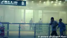 In this photo released by China's Xinhua News Agency, medical workers and policemen work at the terminal 3 of the Beijing International Airport in Beijing, Saturday, July 20, 2013. Chinese state media said that a man set off a homemade bomb in Terminal 3 of the Beijing International Airport, but that no one besides the man was injured and order has been restored. (AP Photo/Xinhua, Chen Jianli) NO SALES