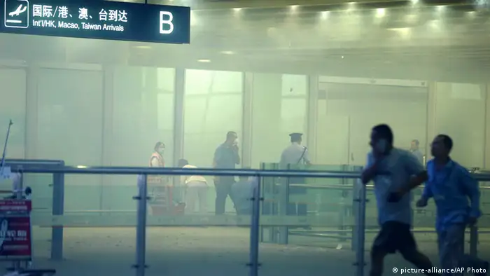 A policeman stands amid smoke at the arrival gate B after an explosion at the Terminal 3 of Beijing Capital International Airport in Beijing, July 20, 2013. A man in a wheelchair detonated a home-made explosive in Beijing airport on Saturday evening, injuring himself and sending smoke billowing through the exit area of the international arrivals section of Terminal 3. REUTERS/Stringer (CHINA - Tags: DISASTER CIVIL UNREST TRANSPORT) CHINA OUT. NO COMMERCIAL OR EDITORIAL SALES IN CHINA