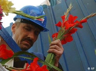 Ein Werftarbeiter legt Blumen nieder