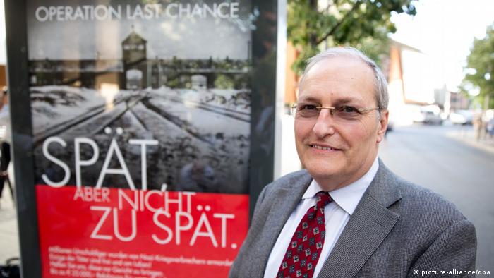 Efraim Zuroff, standing in front of one of the posters Photo: Jörg Carstensen/dpa pixel
