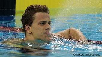 Ein Schwimmer prustet Wasser aus seinem Mund