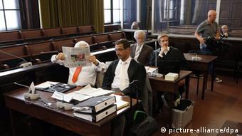[41253758] Prozessbeginn wegen Verstoß gegen Iran-Embargo Zwei Angeklagte (l und 3.v.l.) sitzen mit ihren Anwälten am 24.07.2013 beim Prozessauftakt vor dem Staatsschutzsenat des Hanseatischen Oberlandesgerichts (OLG) in Hamburg. (Foto: Christian Charisius/dpa)