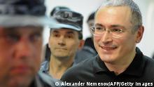 A guard escorts former Yukos oil company CEO Mikhail Khodorkovsky (C) to a courtroom in Moscow, where he will stand as a witness in a trial in absentia of former associate Russian-born Spaniard Antonio Valdez Garcia, who was the head of Yukos subsidiary Fargoil company and is accused of embezzlement. AFP PHOTO / ALEXANDER NEMENOV (Photo credit should read ALEXANDER NEMENOV/AFP/Getty Images) 02 Jun 2011