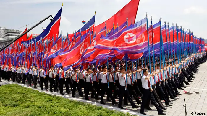 North Koreans holding national flags march during a parade to mark the 60th anniversary of the signing of a truce in the 1950-1953 Korean War at Kim Il-sung Square, in Pyongyang July 27, 2013. REUTERS/Jason Lee (NORTH KOREA - Tags: POLITICS ANNIVERSARY)