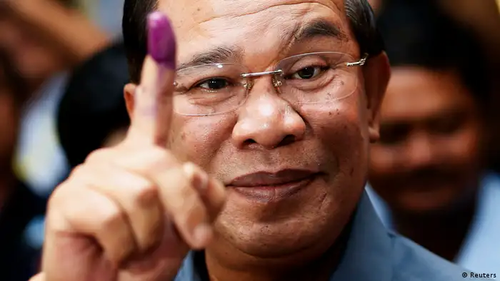 REFILE - CORRECTING COUNTRY IDENTIFIER Cambodia's Prime Minister Hun Sen shows his ink-stained finger after casting a vote in the general elections at a polling station in Kandal province July 28, 2013. REUTERS/Damir Sagolj (CAMBODIA - Tags: POLITICS ELECTIONS TPX IMAGES OF THE DAY)