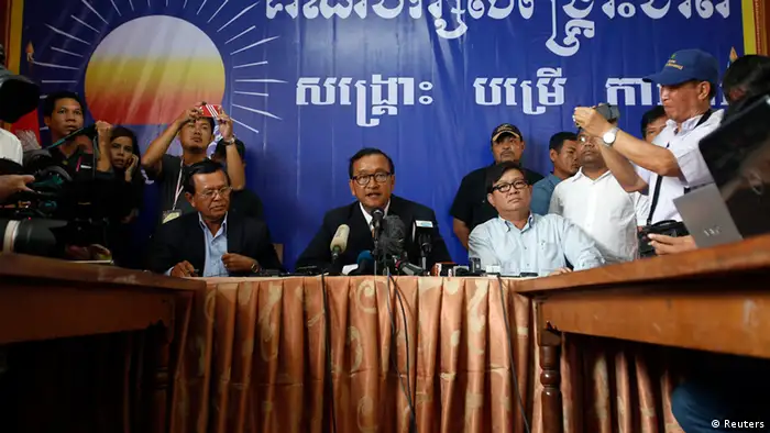 Sam Rainsy (C), president of the Cambodia National Rescue Party (CNRP) addresses reporters at his party's headquarters in Phnom Penh July 29, 2013. Cambodia's main opposition party CNRP on Monday rejected election results given by the government, which said long-serving Prime Minister Hun Sen's party had won, and called for an inquiry into what it called massive manipulation of electoral rolls. REUTERS/Samrang Pring (CAMBODIA - Tags: POLITICS ELECTIONS)