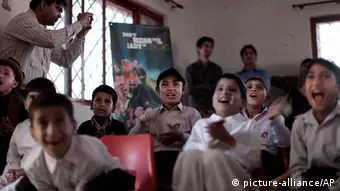 In this Monday, March 25, 2013, photo, Pakistani orphans reacts while watching an early screening of the first episode of the animates Burka Avenger series, at an orphanage on the outskirts of Islamabad, Pakistan. Wonder Woman and Supergirl now have a Pakistani counterpart in the pantheon of female superheroes _ one who shows a lot less skin. Meet Burka Avenger: a mild-mannered teacher with secret martial arts skills who uses a flowing black burka to hide her identity as she fights local thugs seeking to shut down the girls' school where she works. Sadly, it's a battle Pakistanis are all too familiar with in the real world.(AP Photo/Muhammed Muheisen)