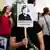Eine Demonstrantin hält am in Berlin ein Plakat mit der Aufschrift "Überwachungskanzlerin" hoch. Foto: Daniel Reinhardt/dpa