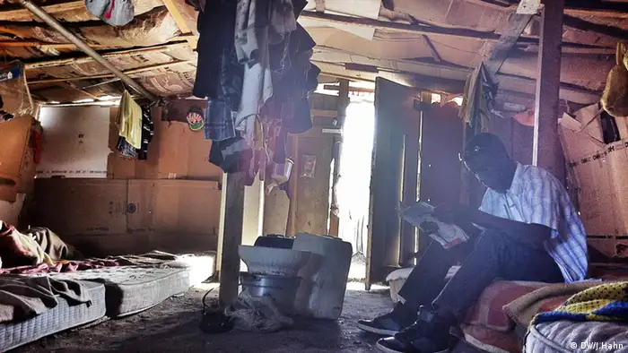 Beschreibung: Ein afrikanischer Einwanderer liest in einer Hütte im Slum nahe der Stadt Foggia. (Foto: Julia Hahn)