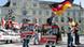Men and women holding signs and German flags at an NPD demonstration Men and women holding signs and German flags at an NPD demonstration