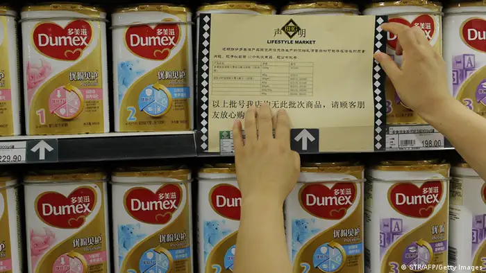 A woman checks a guarantee announcement on a shelf of Dumex baby formula, which uses the New Zealand dairy Fonterra as its raw material supplier, at a supermarket in Hefei, north China's Anhui province, on August 5, 2013. China stepped up warnings to consumers on August 5 over a botulism scare involving products from the New Zealand dairy company Fonterra, and has demanded affected importers check their sales records. CHINA OUT AFP PHOTO (Photo credit should read STR/AFP/Getty Images)