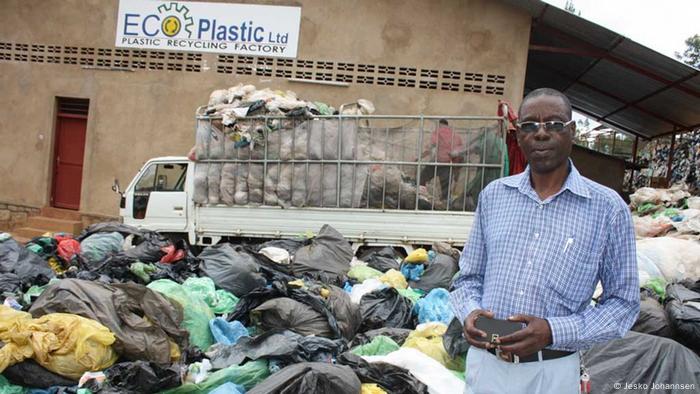 Aloys Niyonsaba steht im Plastikmüll vor seiner Fabrik (Foto: Jesko Johannsen)