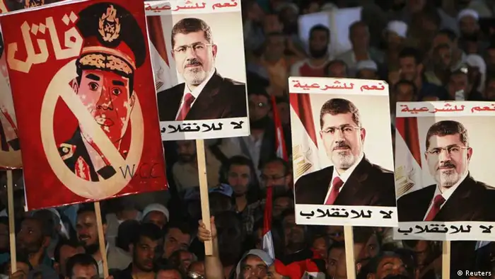 Supporters of deposed Egyptian President Mohamed Mursi hold up posters, including Egypt's army chief General Abdel Fattah al-Sisi (L) that reads, A murderer, during a protest at the Rabaa al-Adawiya square where they are camping, in Cairo, August 6, 2013. The chances for a negotiated end to Egypt's political crisis looked to have hit the rocks on Tuesday with the army-installed government reportedly ready to declare that foreign mediation efforts had failed. It would also declare that Muslim Brotherhood protests against the army's overthrow of Mursi were non-peaceful - a signal that the government intends to end them by force. The posters of Mursi read, Yes to legitimacy, no to the coup. REUTERS/Mohamed Abd El Ghany