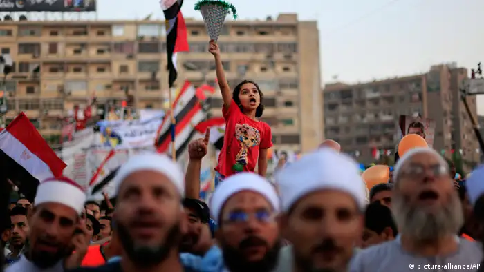 An Egyptian girl chants slogans as she joins supporters of Egypt's ousted President Mohammed Morsi as they celebrate the first day of the Eid al-Fitr holiday, marking the end of the Muslim holy fasting month of Ramadan outside Rabaah al-Adawiya mosque, where protesters have installed a camp and hold daily rallies in Nasr City, Cairo, Egypt, Wednesday, Aug. 8, 2013. This year's holiday of Eid al-Fitr was overshadowed by the deep divisions in Egypt, with the interim government planning to celebrate the festival with outdoor prayers in town center squares and Morsi's supporters marking the holiday with their own protest gatherings, including the two major sit-in by the Islamists in Cairo. (AP Photo/Khalil Hamra)