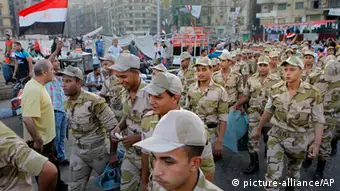 Egyptian army soldiers march into Tahrir Square in Cairo, Egypt, Thursday, Aug. 8, 2013, as they prepare to pray the feast prayers marking the end of the Islamic fasting month of Ramadan. This year's holiday is overshadowed by the deep divisions in Egypt, with the interim government planning to celebrate the feast with outdoor prayers and protests in town center squares and Morsi's supporters marking the holiday with their own protests and prayers, including at the two major sit-ins by the Islamists in Cairo. (AP Photo/Amr Nabil)