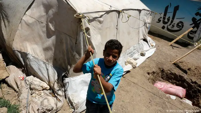 Ein Junge vor einem Zelt in einem syrischen Flüchtlingslager im Libanon im Sommer 2013. Copyright: World Vision Deutschland.