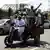 Eine Gruppe junger Anhänger des Ex-Prsäidenten Mursi fährt auf einem Motorad durch die Straßen Kairos und hält Pro-Mursi-Plakate hoch (Foto: AFP)