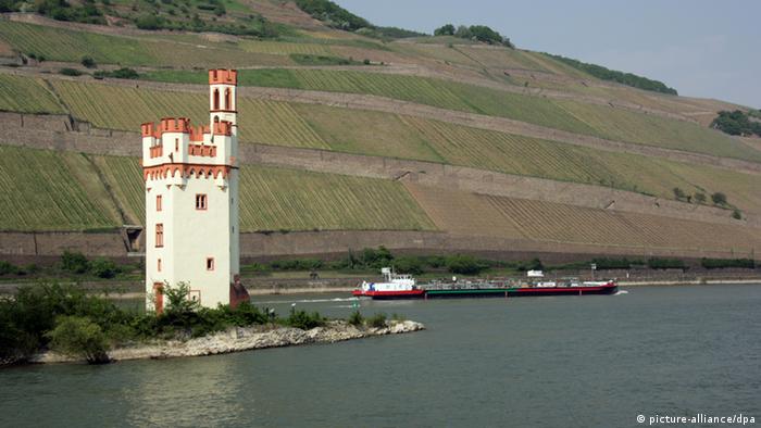 Ein Binnenschiff auf dem Rhein fährt entlang des Mäuseturms in Bingen