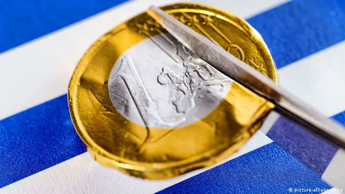 Schere schneidet Euromünze durch, Schuldenschnitt für Griechenland