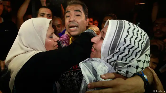 A freed Palestinian prisoner is hugged by his mother (R) upon his arrival near Erez Crossing, between Israel and northern Gaza Strip, early August 14, 2013. Israel freed 26 Palestinian prisoners on Wednesday to keep U.S.-sponsored peacemaking on course for a second round of talks, but diplomacy remained dogged by Israeli plans for more Jewish homes on land the Palestinians claim for a future state. REUTERS/Mohammed Salem (GAZA - Tags: POLITICS)