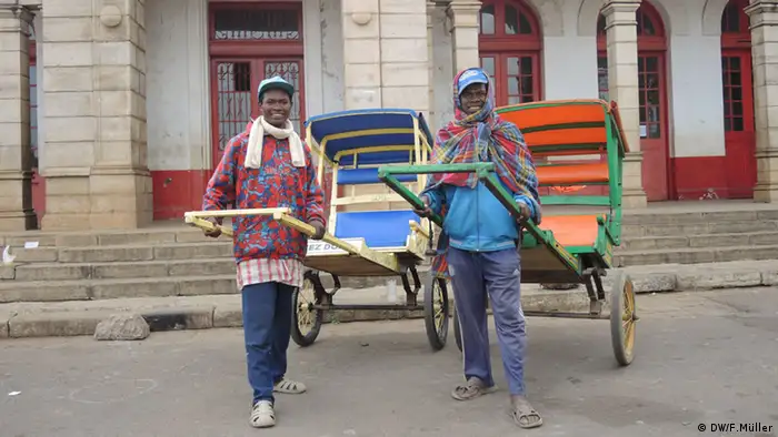 Die beiden Rikscha-Fahrer Jean-Noël und Erick Régis vor dem alten Bahnhof in Antsirabe, Madagaskar (Foto: Friederike Müller/DW)