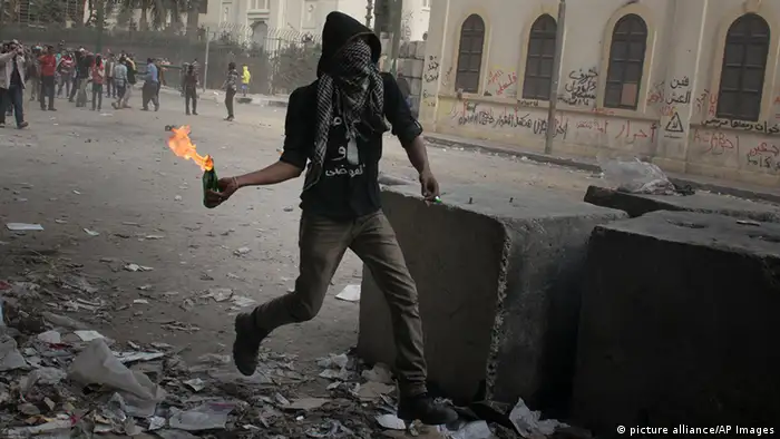 An Egyptian throws a Molotov cocktail bomb over a wall as protesters clashed with police in Tahrir Square in Cairo on Thursday Jan. 24, 2013, the eve of the the second anniversary of the uprising that overthrew Hosni Mubarak. (AP Photo/Tribune Review, Justin Merriman) PITTSBURGH OUT
