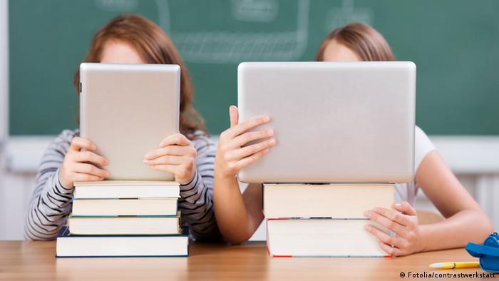 Zwei Schülerinnen lesen mit Laptop und Tablet-PC (Foto: Fotolia/contrastwerkstatt)