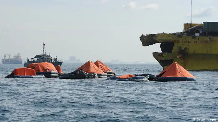 Life rafts from the sunken ferry St. Thomas Aquinas float next a cargo ship (R) on August 17, 2013 whose bow was destroyed after a colliding with the ferry the night before off the town of Talisay near the Philippines' second largest city of Cebu. Philippine rescuers searched on August 17 for more than 200 people missing after the ferry collided with the cargo ship in thick darkness and sank almost instantly, with 26 already confirmed dead. AFP PHOTO / TED ALJIBE (Photo credit should read TED ALJIBE/AFP/Getty Images)
