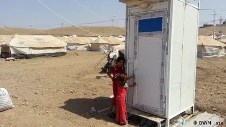 A Syrian girl outside a white mobile toilet. (Photo: Mihyedin Isso) 