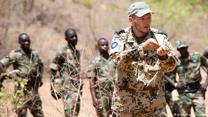 A German soldier leads a group of Malian soldiers