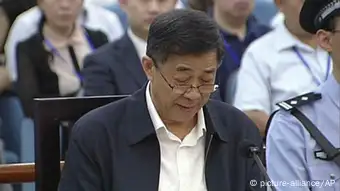 In this image taken from video, Former Chinese politician Bo Xilai reads in a court room at Jinan Intermediate People's Court in Jinan, eastern China's Shandong province, Sunday, Aug. 25, 2013. Bo on Sunday sought to discredit his former top aide as a lying, unreliable witness as the ousted leader denied criminal responsibility in the country's messiest political scandal in decades.decades. (AP Photo/CCTV via AP Video) CHINA OUT, TV OUT ***FREI FÜR SOCIAL MEDIA***