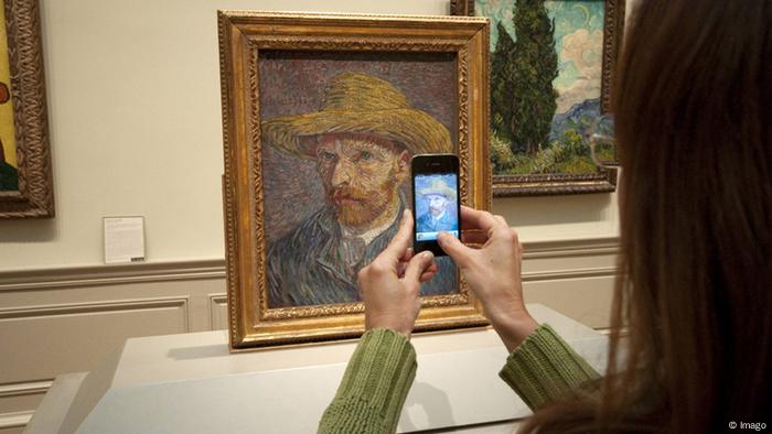 Frau macht mit einem Handy ein Foto von einem gemalten Selbstporträt (Foto: imago/CHROMORANGE)