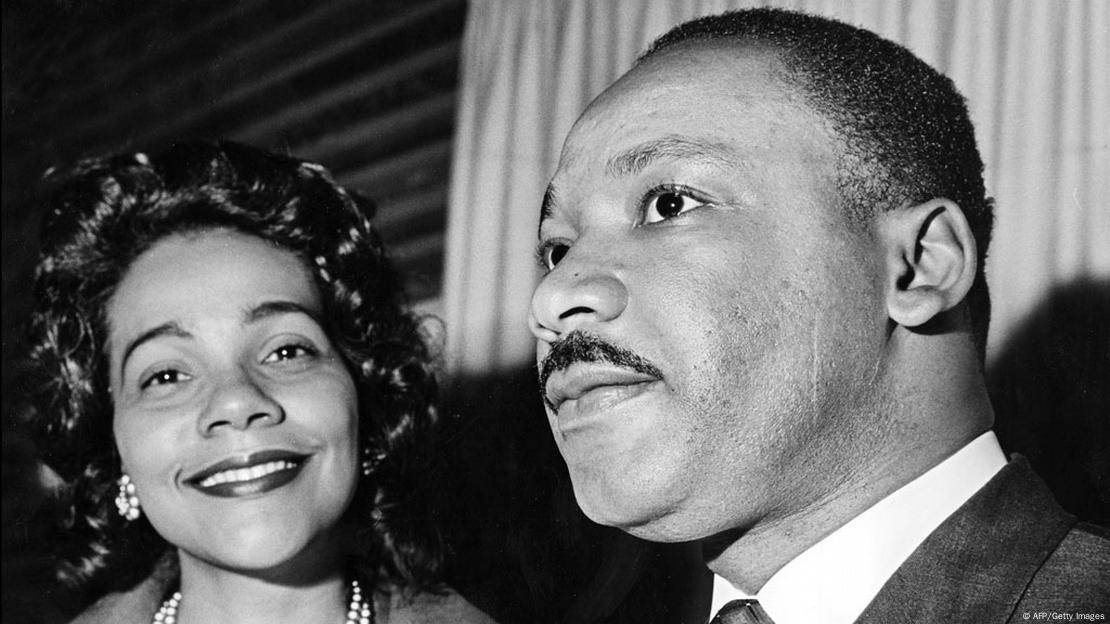 Foto em preto e branco. Coretta olha para a câmera e sorri, ao lado de Martin Luther King