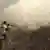 An image grab taken from a video shows opposition fighter holding a rocket propelled grenade (RPG) as his fellow comrades take cover from an attack by regime forces on August 26, 2013 during clashes over the strategic area of Khanasser, situated on the only road linking Aleppo to central Syria. Rebels had in recent days captured several villages in Aleppo province, much of which is already in the hands of anti-regime fighters, before taking Khanasser, situated on the highway to Hama in central Syria, thus cutting the army's only supply route to the northern province. AFP PHOTO / SALAH AL-ASHKAR (Photo credit should read SALAH AL-ASHKAR/AFP/Getty Images)