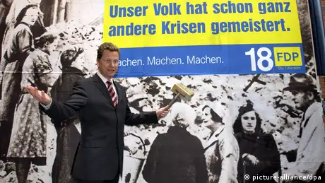 FDP-Chef Guido Westerwelle vor einem Wahlplakat der Liberalen. Das Motto Unser Volk hat schon ganz andere Krisen gemeistert steht auf der Abbildung von arbeitenden Trümmerfrauen.
(c) picture-alliance/dpa