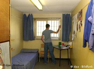 A young man in a youth custody room with barred windows
