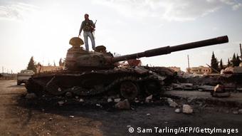 Ein Kämpfer der Freien Syrischen Armee posiert auf einem Panzer vor der untergehenden Sonne. (Foto: AFP PHOTO/SAM TARLING)