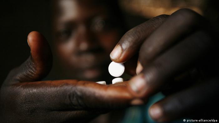A woman infected with the HIV virus takes her medicine in a refugee camp near Gulu in Uganda.