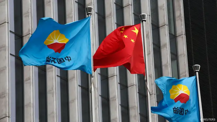 A Chinese national flag flutters between PetroChina's flags at PetroChina's headquarters in Beijing August 28, 2013. The Hong Kong-listed shares of China's dominant oil producer PetroChina Co Ltd and its natural gas distribution arm Kunlun Energy tumbled on Wednesday after they said several senior executives at the group were being investigated over alleged wrongdoing. REUTERS/Kim Kyung-Hoon (CHINA - Tags: BUSINESS)