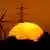 Ветрогенератор и ЛЭП на фоне восходящего солнца