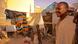 Matallah and his son stand between the huts they live in Matallah and his son stand between the huts they live in