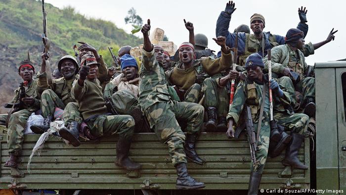 Congolese soldiers crowded onto the back of a truck hold up their hands and weapons in jubilation after their victory over the M23 rebels. Photo: Carl de Souza/AFP/Getty Images