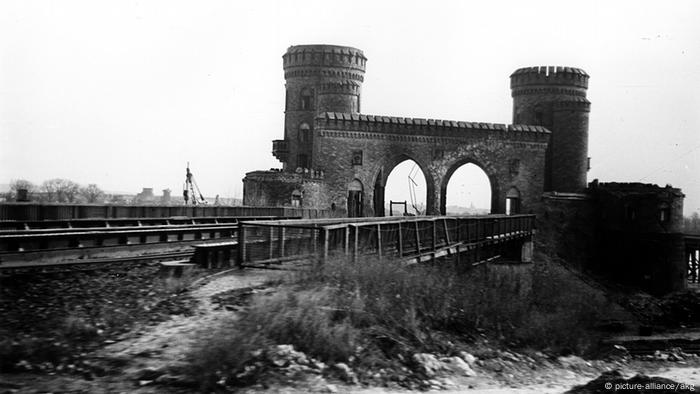 A black and white image of the two remaining towers of the Ludendorff Bridge. 